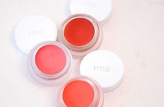 Four jars of RMS cream blushes in various colors.