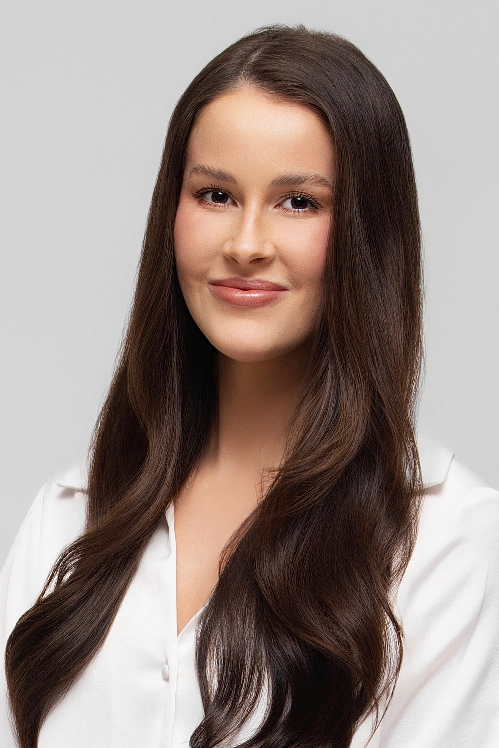 Smiling woman with long brown hair in black shirt.