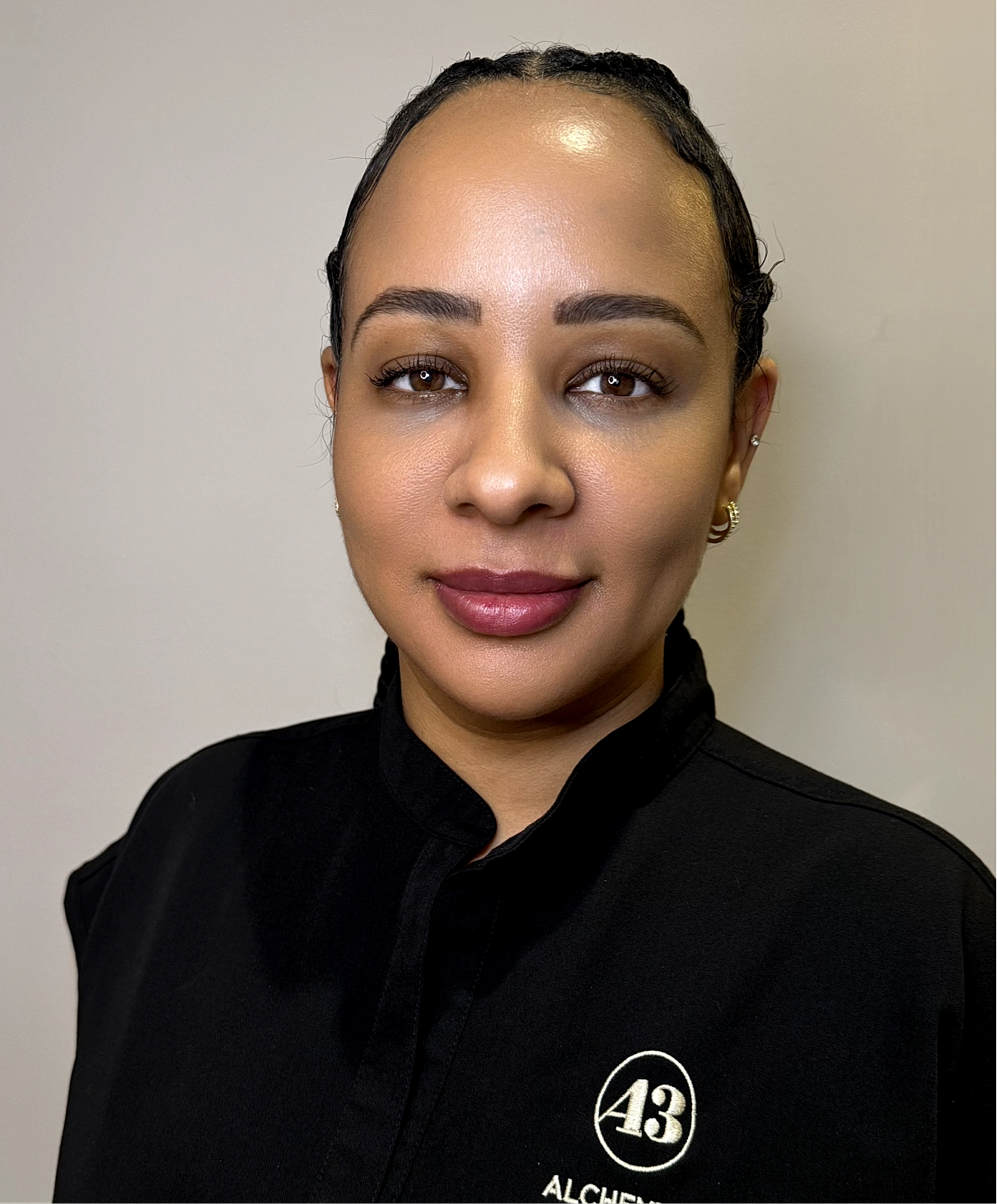 Female professional in black uniform, headshot.