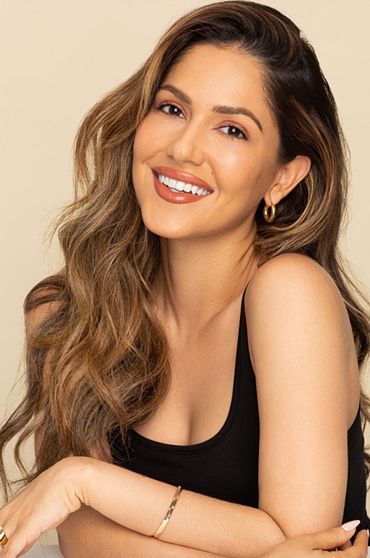 Smiling woman with long hair and natural makeup.